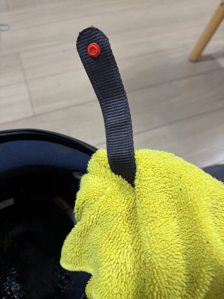 濡れた布でヘルメットのあご紐を拭く